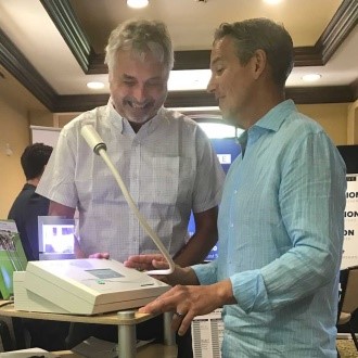 Hans Eng demonstrates the NanoVi to Dr. Daniel Pompa on the trade floor at Mindshare